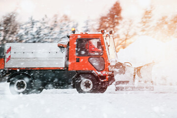Road maintenance in winter. a tractor equipped with a spreader sprays a salt and sand mixture on...