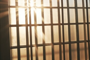 A jail cell with the sun shining through the bars. Can be used to depict imprisonment, confinement, or the hope of freedom