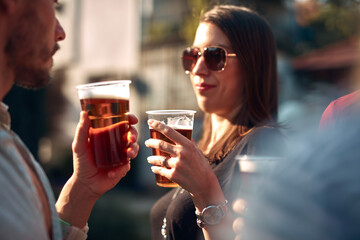 Group of friends enjoying cold beer at a backyard party.