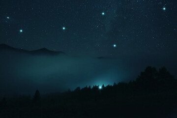 Foggy hill under starry sky at night