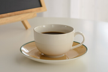 White coffee cup on white table.