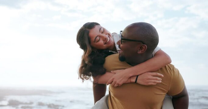 Beach, piggy back and couple with smile, holiday and fun with vacation, romance and bonding together. Adventure, interracial and man carry woman with love, relationship and seaside with marriage