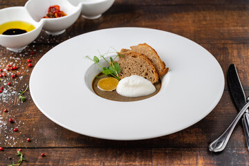 Crostini Fegatini on white porcelain plate on wooden table