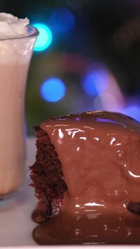 Chocolate muffin and coffee cocktails with whipped cream. Copy space. Cocoa Hot chocolate coffee Brownie cake with cream against the backdrop of Christmas tree or city lights