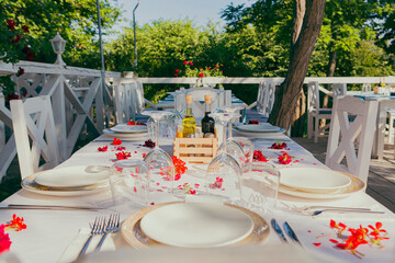 a beautifully arranged table against a backdrop of lovely greenery. beautiful white table, chairs...