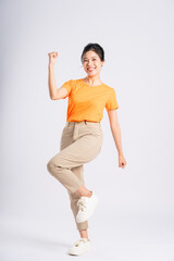 Portrait of cheerful happy Asian woman posing on white background