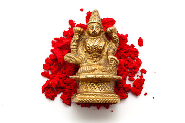 The brass idol of the Hindu Goddess Lakshmi is placed over a red-colored sindoor (vermilion)...
