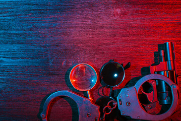 Police inspector handcuffs and gun on the black table flat lay background. Top view. Security....