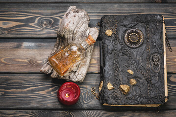 Spell book and magic potion bottle on the wooden table flat lay background. Top view.