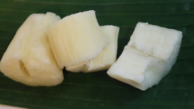 Singkong rebus, boiled cassava on green banana leaf isolated white