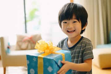 Cute asian little boy holding a gift box