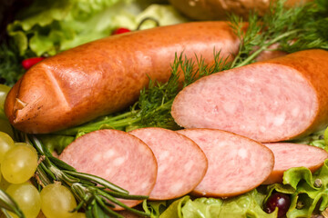 Sliced ​​homemade smoked sausage with dill, grapes and other spices