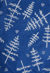 Wrapping paper for gifts with winter print. Blue background with white fir trees. Textured Christmas background. Christmas. New Year.