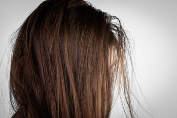 Young woman with dirty greasy hair on gray background. - obrazy, fototapety, plakaty
