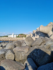 Jeju Island beach with breakwater and basalt rocks.