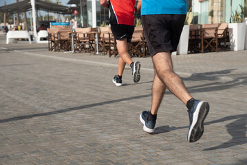 Fototapeta premium Person running on marathon racing. People exercising outdoors. Healthy lifestyle.