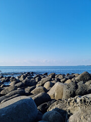 Jeju Island's sea with black basalt rocks.