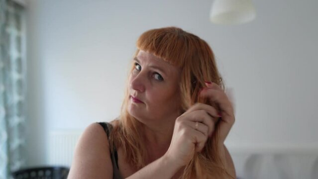 Woman taking care long red hair