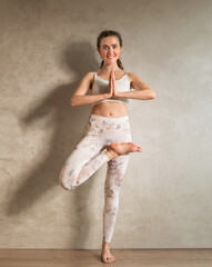 Yoga im Studio, junge Frau mit Körperübungen für Gleichgewicht, Balance und Konzentation	 - obrazy, fototapety, plakaty