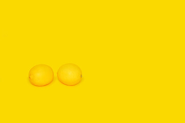 two lemons on a yellow background