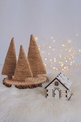 Small wooden house with christmas tree and bokeh background.