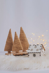 Small wooden house with christmas tree and bokeh background.