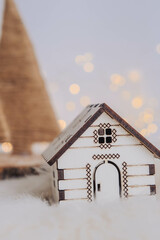 Small wooden house with christmas tree and bokeh background.