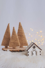 Small wooden house with christmas tree and bokeh background.