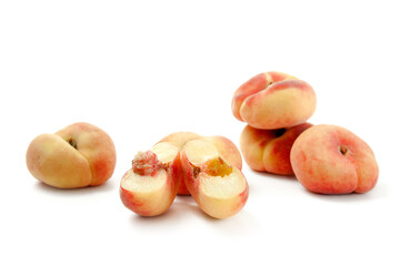 Half and several whole saturn peaches or flat peaches isolated on white background with clipping...
