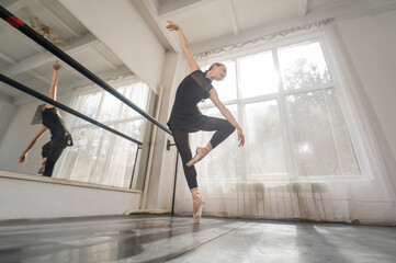 A beautiful Asian woman is dancing at the barre. Ballet dancer.
