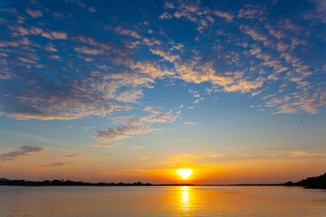 sunset at the riverside. cloud sky reflected in water