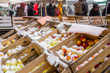 Marktstand mit schneebedeckten Äpfeln in Obstkisten