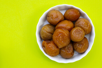 Pickled plums on green background.