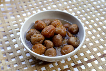 Pickled plums in white bowl