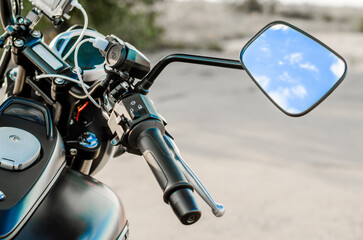 Fototapeta na wymiar reflection of the nab and clouds in the motorcycle mirror, motorcycle steering wheel and motorcycle fuel tank