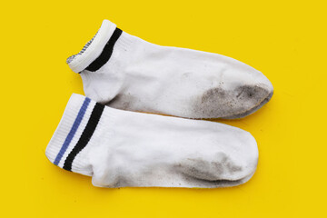 Dirty white socks on yellow background.