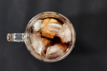Clear glass with ice and nectar on a gray-black background.