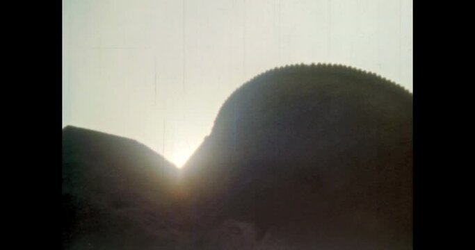 Sheer impregnable fortress wall in sunset sunlight. Medieval defensive castle bastion outside exterior. Down-up epic view of historic landmark. Vintage footage of overscan archival film. 1980s archive