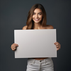 Naklejka premium A woman with a smile is holding a white board