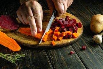 The cook is preparing a vinaigrette. Knife in the hand of a chef on the kitchen table for cutting...