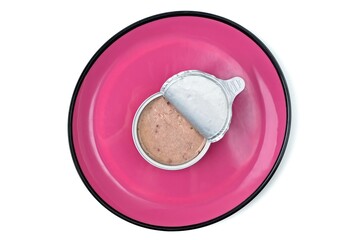 Open package of wet pet food on pink plate,  seen directly from above. Isolated on white background.
