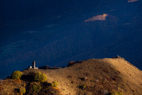 mountain ranges at sunset, an ancient tower at the top of the pass