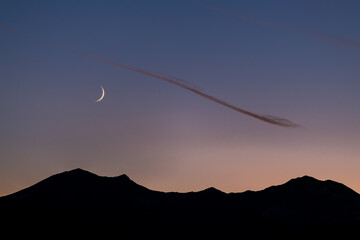 crescent moon over mountain range