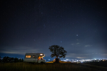 motorhome at night near a tree  and starry sky