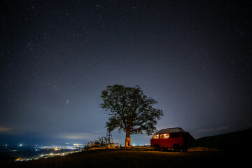 motorhome at night near a tree  and starry sky