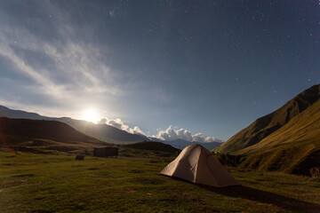 Hiking tent in the mountains against the at night