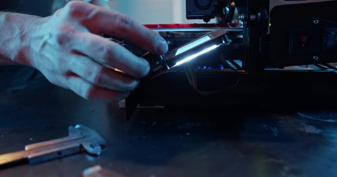 Crop craftsman setting up professional 3D printer