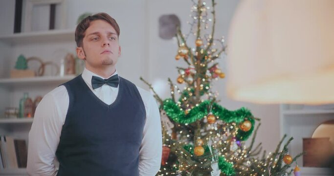 Thoughtful man standing by decorated Christmas tree at home