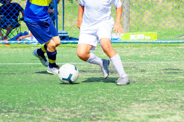 Young people in football match action on green synthetic field