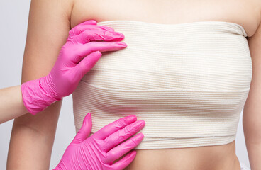 Bandage on a woman's chest. Breast augmentation. Silicone breast
